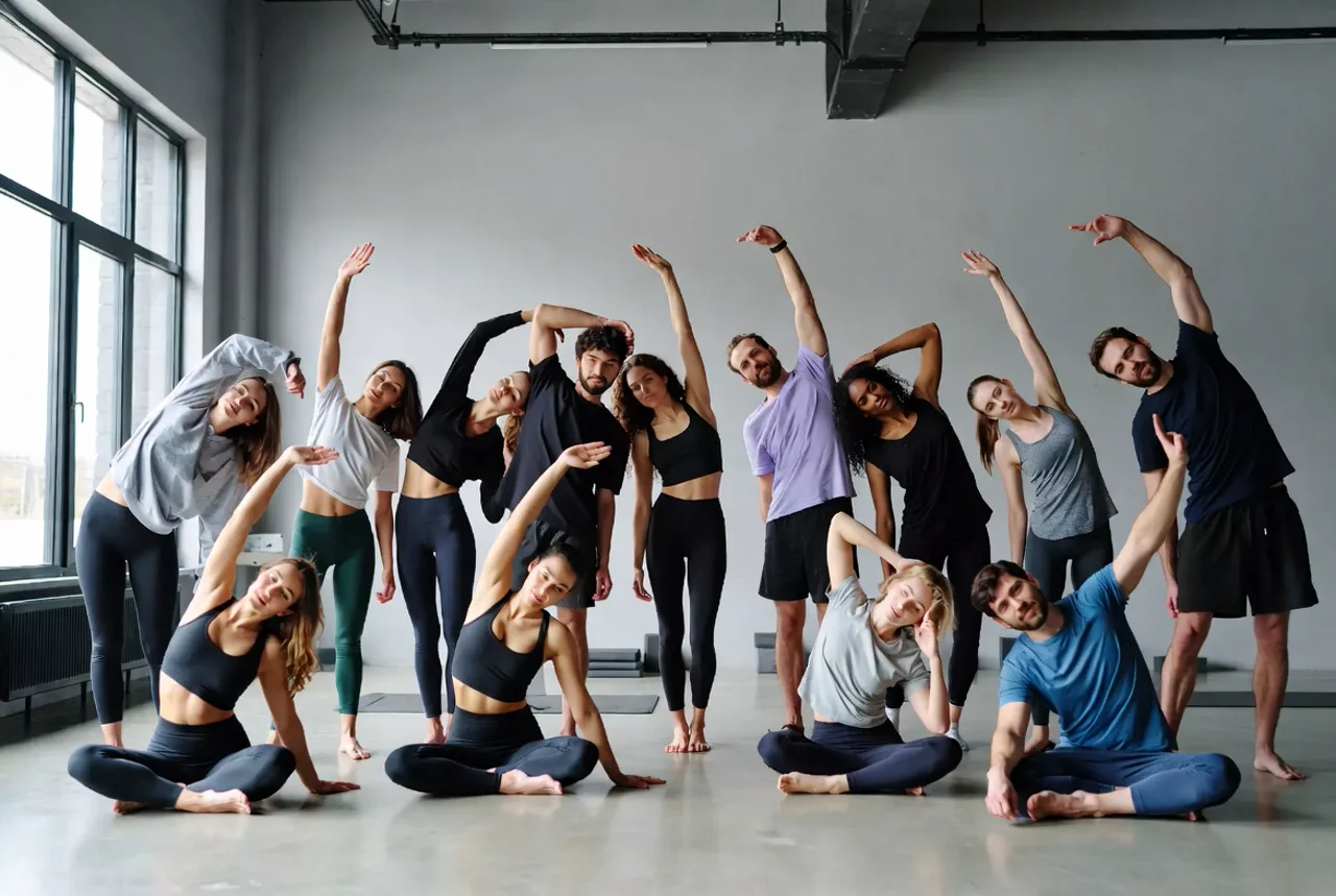 Gruppe von Menschen beim gemeinsamen Stretching in einem hellen modernen Studio